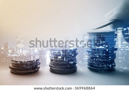 Double exposure of city and rows of coins for finance and banking concept