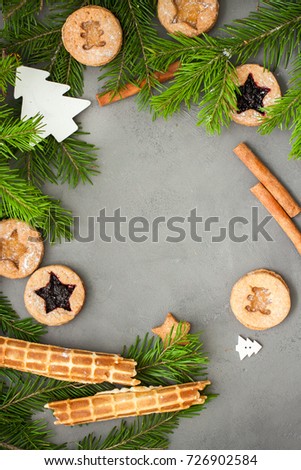 Ginger homemade cookies with strawberry jam on gray concrete background with Christmas tree. View with copy space. Flat lay, top view. Christmas Border -banner.