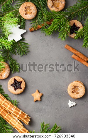 Ginger homemade cookies with strawberry jam on gray concrete background with Christmas tree. View with copy space. Flat lay, top view. Christmas Border -banner.
