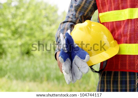 man holding yellow helmet in the outdoors