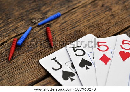 A Low Angle View Of Four Playing Cards And Cribbage Pegs On Wooden Table Top A Low Angle View Of Four Playing Cards And Cribbage Pegs On Wooden Table Top
