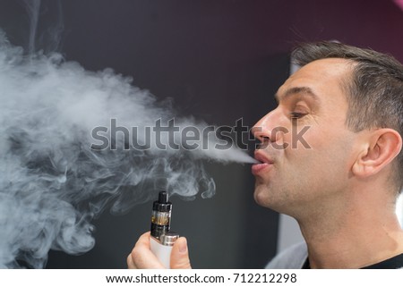 stock-photo-man-exhaling-vapor-from-an-electronic-cigarette-712212298.jpg