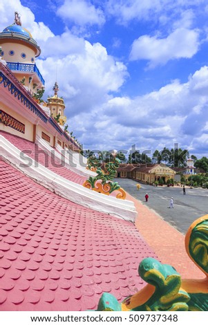 TAY NINH, VIETNAM - October 23, 2016:roof of Cao Dai temple area and meditating followers of the Cao Dai religion in the temple Cao Dai