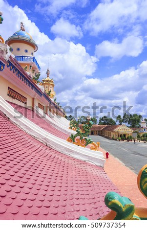 TAY NINH, VIETNAM - October 23, 2016:roof of Cao Dai temple area and meditating followers of the Cao Dai religion in the temple Cao Dai