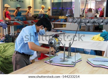 NHA TRANG, VIETNAM - JUNE 04, 2015: A Vietnamese worker at the Saga Du Mekong garment factory. The factory specialises in linen, silk, bamboo and fine cotton clothing.