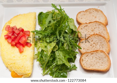home made omelette with cheese tomato and rucola rocket salad arugola - stock photo