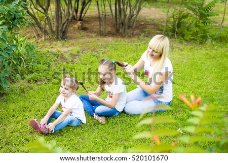 Young mother and two daughters playing in grass