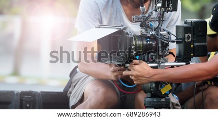 Behind the scenes of movie shooting or video production and film crew team with camera equipment at outdoor location.