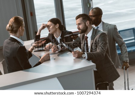 group of angry businesspeople having argument with airport receptionist