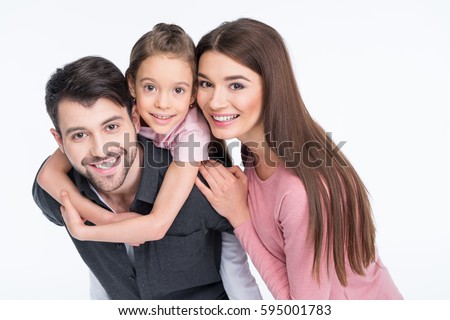 Happy young family with one child smiling at camera on white
