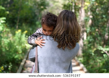 Mother holds and comforts sad little boy