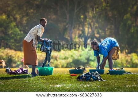 Two women washing clothes on the banks of Lake Naivasha National Park. 02. 01. 2006 Africa. Kenya.