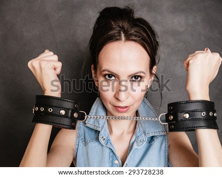 Arrest and jail. Criminal woman prisoner girl showing leather handcuffs ...