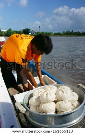 CA MAU, VIET NAM- JUNE 29: Amazing view with food vendor, he drive the motor boat and sell dumpling on riverr, this is special culture of Mekong delta, Ca Mau, Vietnam, June 29, 2013