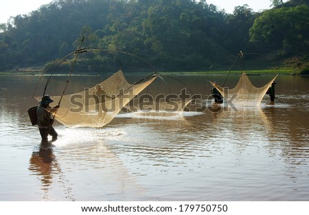BUON ME THUOT, VIETNAM- FEB 7: People catch fish on ditch, fisherman lifting net from water, lift net is primitive traditional tool, include net, rod, four corner hang up 4 frame, Vietnam, Feb 7, 2014
