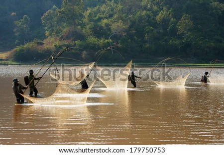 BUON ME THUOT, VIETNAM- FEB 7: People catch fish on ditch, fisherman lifting net from water, lift net is primitive traditional tool, include net, rod, four corner hang up 4 frame, Vietnam, Feb 7, 2014