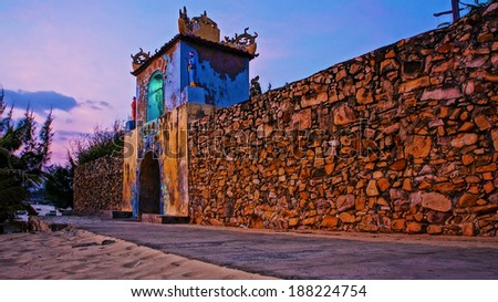 BINH THUAN, VIET NAM- JAN 21: sunrise sky at ancient temple gate, the temple with long stone wall, antique architecture of spirit place, Vietnam, Jan 21, 2014