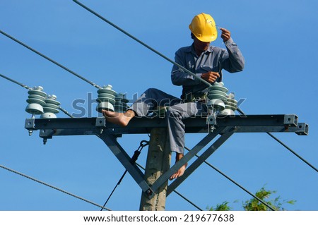 DONG THAP, VIET NAM- SEPT 23: Asian electrician climb high in pole to work, lineman with cable network, man repair electric post danger and unsafe, is industry service, Vietnam, Sept 23, 2014