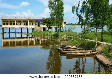 DONG THAP, VIET NAM- SEPT 19: Landscape of Vietnamese shool in flooded season, shool reflect on water, group of row boat floating on river, vehicle of waterway Mekong Delta, Vietnam, Sept 19, 2014