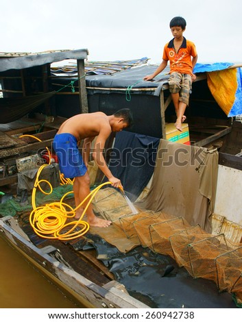 DONG NAI- VIET NAM- AUST 31: Group of Asian fisherman fishing on Tri An lake, a branch of Dong Nai river, crowd of people collect river fish on row boat, Vietnam, Aust 31, 2014