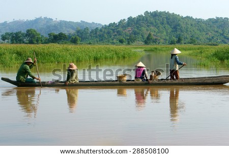 DAK LAK- VIET NAM- JUNE11: Group of Asian farmer go to work by row boat on Lak lake in summertime, family of ethnic minority, grass on lake, amazing view for Asia travel, Daklak, Vietnam, June11, 2015
