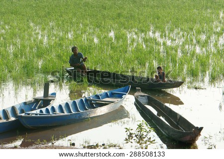 DAK LAK- VIET NAM- JUNE11: Group of Asian farmer go to work by row boat on Lak lake in summertime, family of ethnic minority, grass on lake, amazing view for Asia travel, Daklak, Vietnam, June11, 2015
