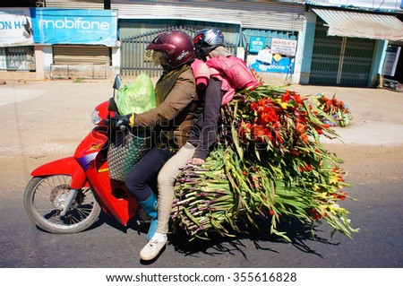DONG NAI, VIET NAM- FEB 6: Danger traffic on highway, couple transport overload flower and moving on street, insecure situation by vehicle as motorbike increase in spring, Dongnai, Vietnam, Feb 6,2014