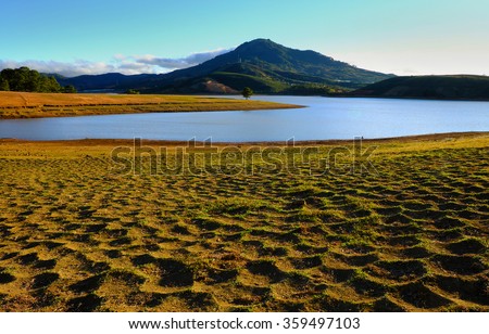 Beautiful panorama landscape at Dalat countryside, Vietnam, amazing wide grass in yellow morning, lake among pine forest, mountain far away, pine tree, wonderful scene for Da Lat, Viet Nam travel