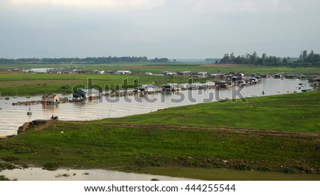 DONG NAI, VIET NAM- JUNE 5: Group of floating house on La Nga fishing village, river with green grass and hyacinth, residence of people who live with fish farming at Dongnai, Vietnam