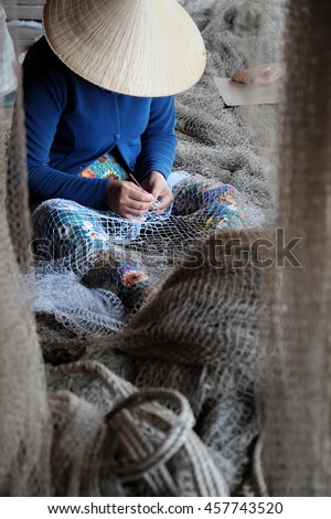 Vietnamese woman sewing fishing net at Ca Mau,Vietnam