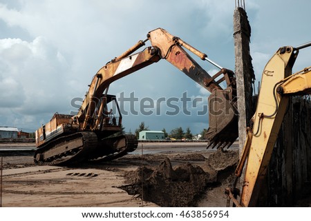 CA MAU, VIET NAM- JULY 16,2016: Vietnamese excavator driver control vehicle to build breakwater at beach to protect seaside from erosion at Camau, Vietnam