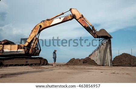 CA MAU, VIET NAM- JULY 16,2016: Vietnamese excavator driver control vehicle to build breakwater at beach to protect seaside from erosion at Camau, Vietnam