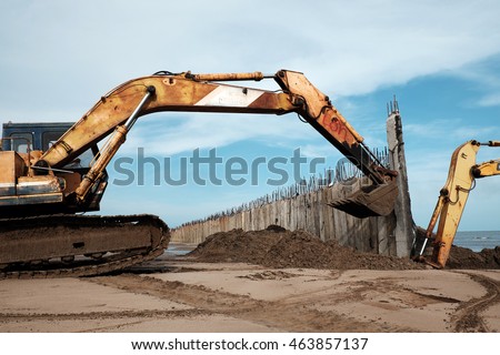 Vietnamese excavator driver control vehicle to build breakwater at beach to protect seaside from erosion at Camau, Vietnam