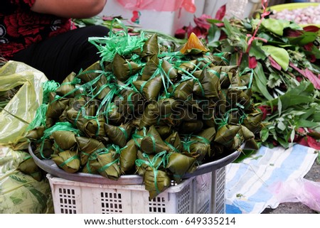Vietnamese traditional food for may 5th, is double five festival or tet doan ngo, group of sticky rice cake in green leaf, also call banh u tro with pyramidal shape at open air market