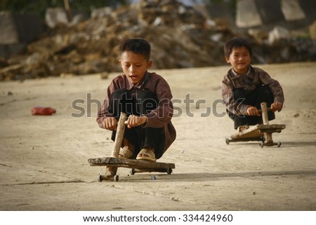 Y Ty, Lao Cai province, Viet Nam - Sept 27, 2015 - Children playing with homemade wooden car in northern Vietnam highlands near the Chinese border.