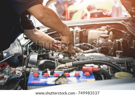 Auto mechanic working in garage. Repair service.
