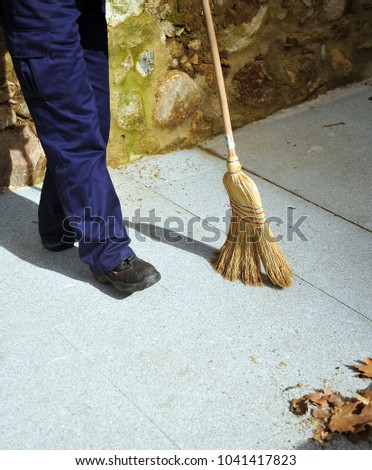 Sweeper, municipal cleaning worker sweeping the autumn leaves