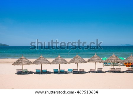Beach umbrellas and deck chairs in front of the My Khe beach in Da Nang, Vietnam