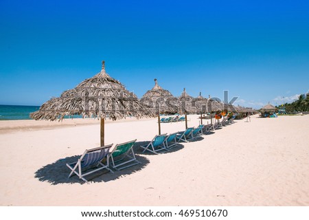 Beach umbrellas and deck chairs in front of the My Khe beach in Da Nang, Vietnam