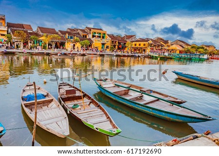 HOI AN, VIETNAM - MARCH 17, 2017: Traditional boats in front of ancient architecture in Hoi An, Vietnam. Hoi An is the World's Cultural heritage site, famous for mixed cultures & architecture.