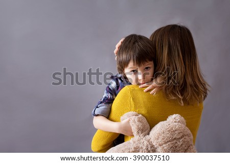 Sad little child, boy, hugging his mother at home, isolated image, copy space. Family concept