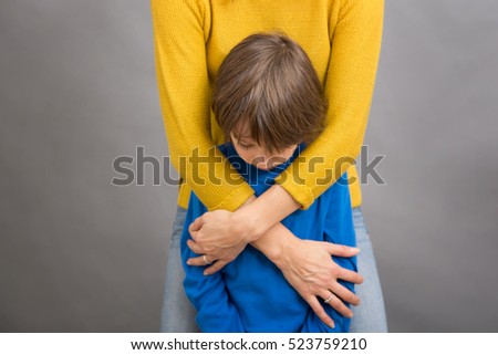 Sad little child, boy, hugging his mother at home, isolated image, copy space. Family concept