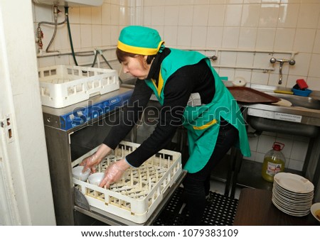 Social Worker Putting Dirty Dishes In Dishwasher At The Kitchen Opening Center Of Social Worker Putting Dirty Dishes In Dishwasher At The Kitchen Opening Center Of
