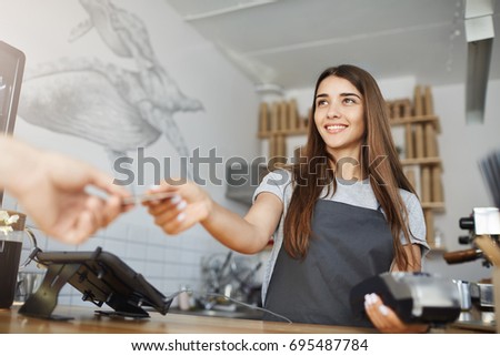 Female interacting with customer using a bank terminal to process and acquire credit card payments.