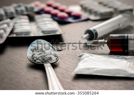 Drug syringe and cooked heroin on spoon