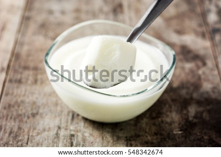 Greek yogurt in glass bowl on wooden table