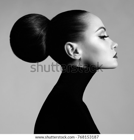 Black and white fashion art studio portrait of beautiful elegant woman in black turtleneck. Hair is collected in high beam. Elegant ballet style
