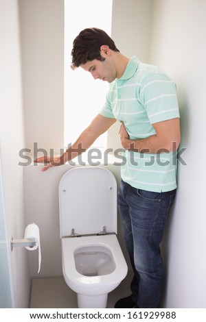 Side view of a young man with stomach sickness about to vomit into the ...