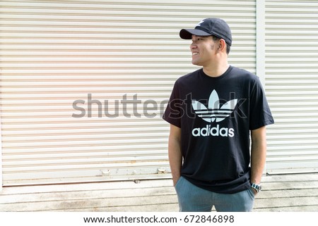 BANGKOK, THAILAND - JULY 2, 2017: Adidas logo on man T-shirt and cap. Adidas is German designer and manufacturer of sports clothing and accessories; largest in Europe and 2nd biggest in the world.