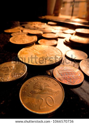 Closeup Of Bunch Of International Coins From Singapore 20 Cents Us 5 1 Cents Indian 10 Ruplaced On Black Background With Evening Golden Sunlight Closeup Of Bunch Of International Coins From Singapore 20 Cents Us 5 1 Cents Indian 10 Ruplaced On Black Background With Evening Golden Sunlight